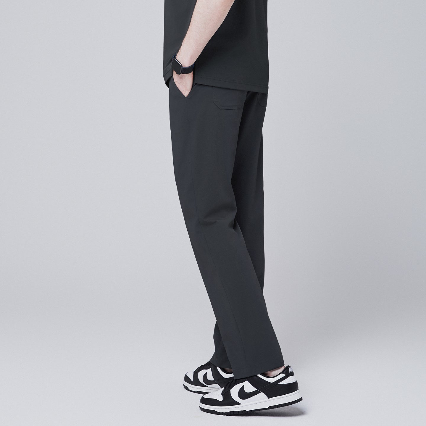 Rear side view of deep gray straight scrub pants with back pocket details, paired with black and white sneakers, modeled against a neutral gray background,Deep Gray