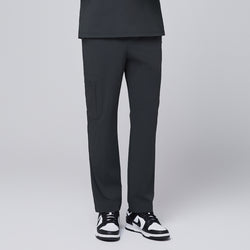 Image of Front view of deep gray scrub pants featuring a sleek zipper pocket on the side, paired with black and white sneakers, modeled against a neutral gray background,Deep Gray