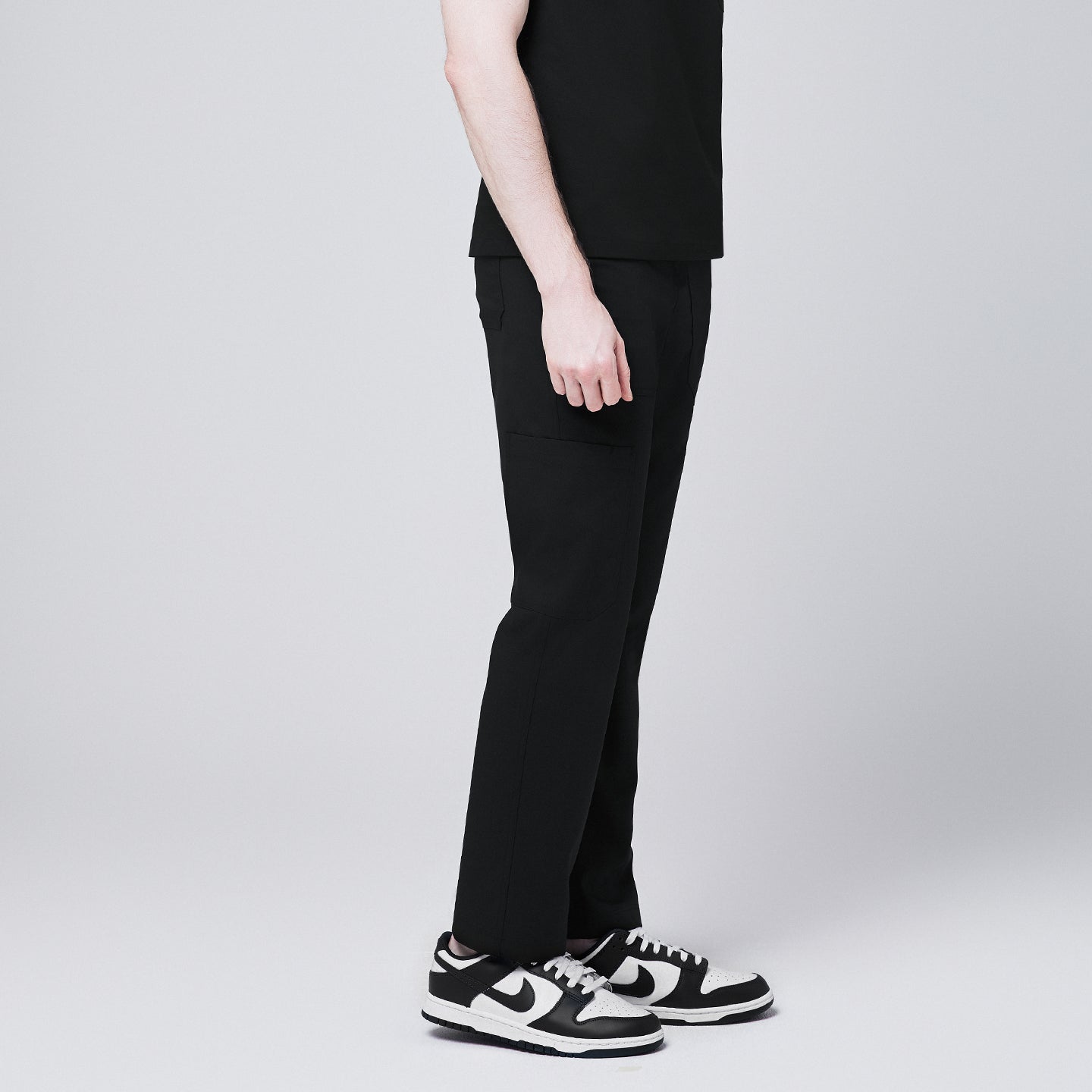 man side view, wearing Zenir eco-black 8-pocket straight scrub pants with black-and-white sneakers,Eco Black