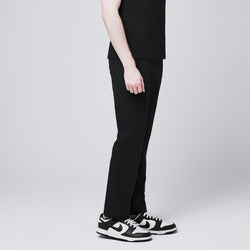 Image of man side view, wearing Zenir eco-black 8-pocket straight scrub pants with black-and-white sneakers,Eco Black