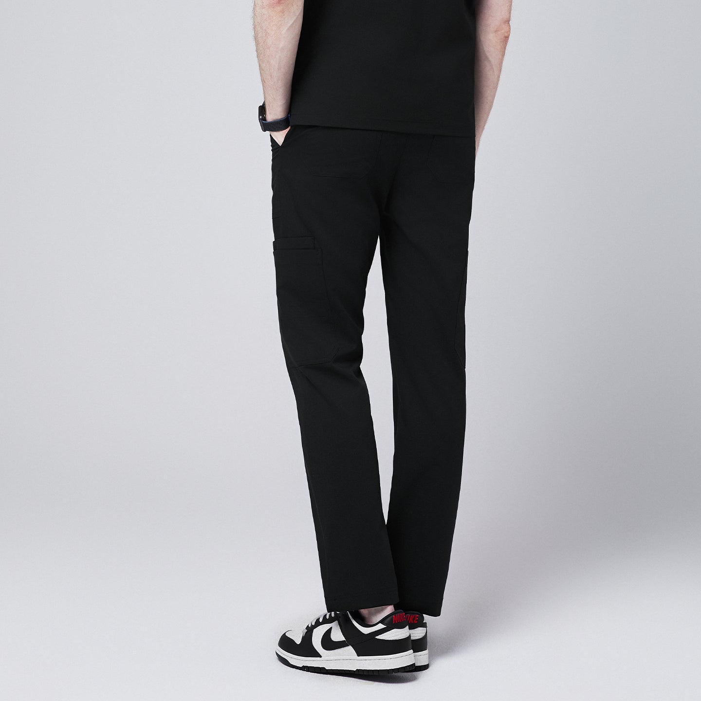 man back view, wearing Zenir eco-black 8-pocket straight scrub pants paired with black-and-white sneakers,Eco Black