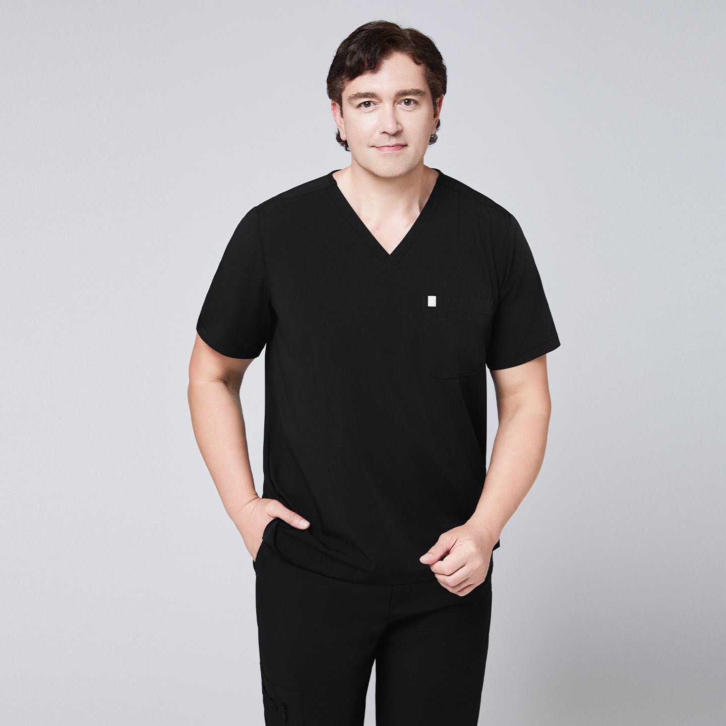 Man in a black scrub set with a single-pocket V-neck top and relaxed fit pants,Eco Black