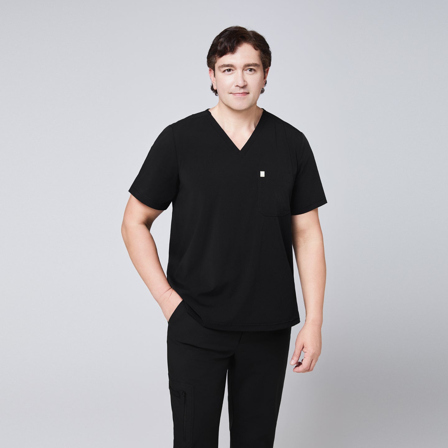 Man wearing a black scrub set with a single-pocket V-neck top, designed for healthcare professionals,Eco Black