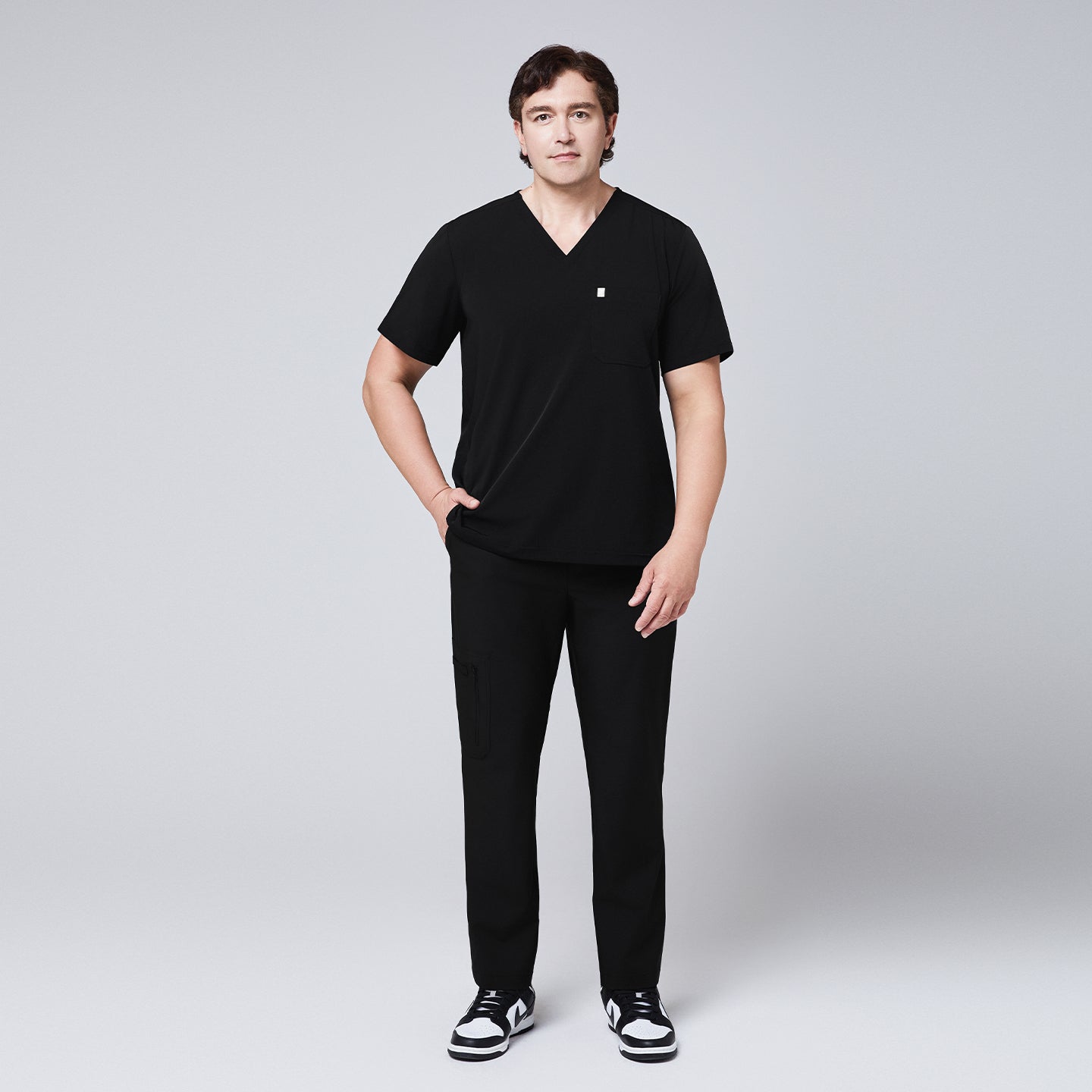 Man wearing a black scrub set with a single-pocket V-neck top, designed for healthcare professionals,Eco Black