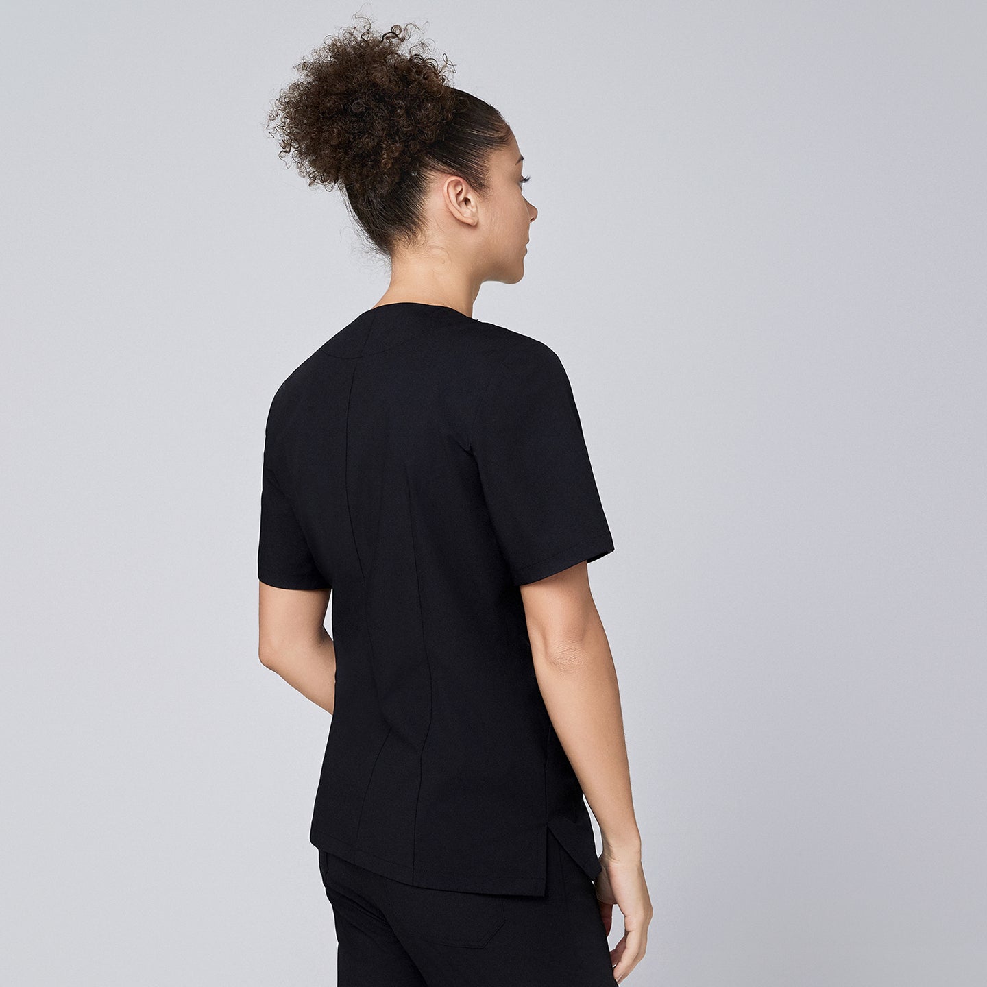 Eco black scrub top with quarter zipper, worn by model with arms relaxed at sides,Eco Black