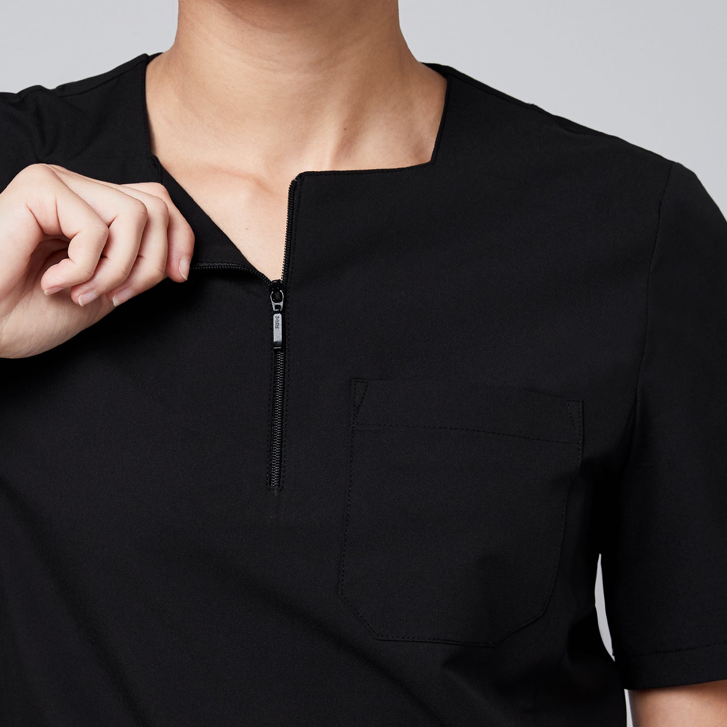 Black quarter-zip scrub top with a functional zipper, chest pocket, and short sleeves, designed with eco-friendly fabric for comfort and durability,Eco Black