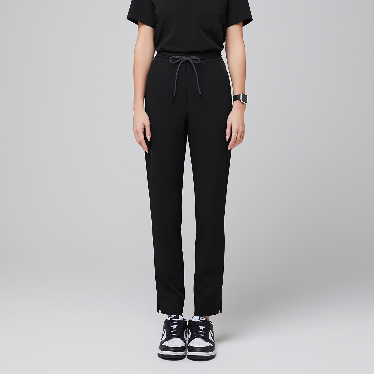 Streamlined scrub pants featuring a drawstring waist, zipper pocket, and split hem, paired with casual sneakers for a professional yet relaxed look,Eco Black