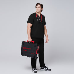 Image of Male model in black scrub pants holding a Milwaukee Fuel case, styled with a stethoscope around his neck and sneakers,Eco Black