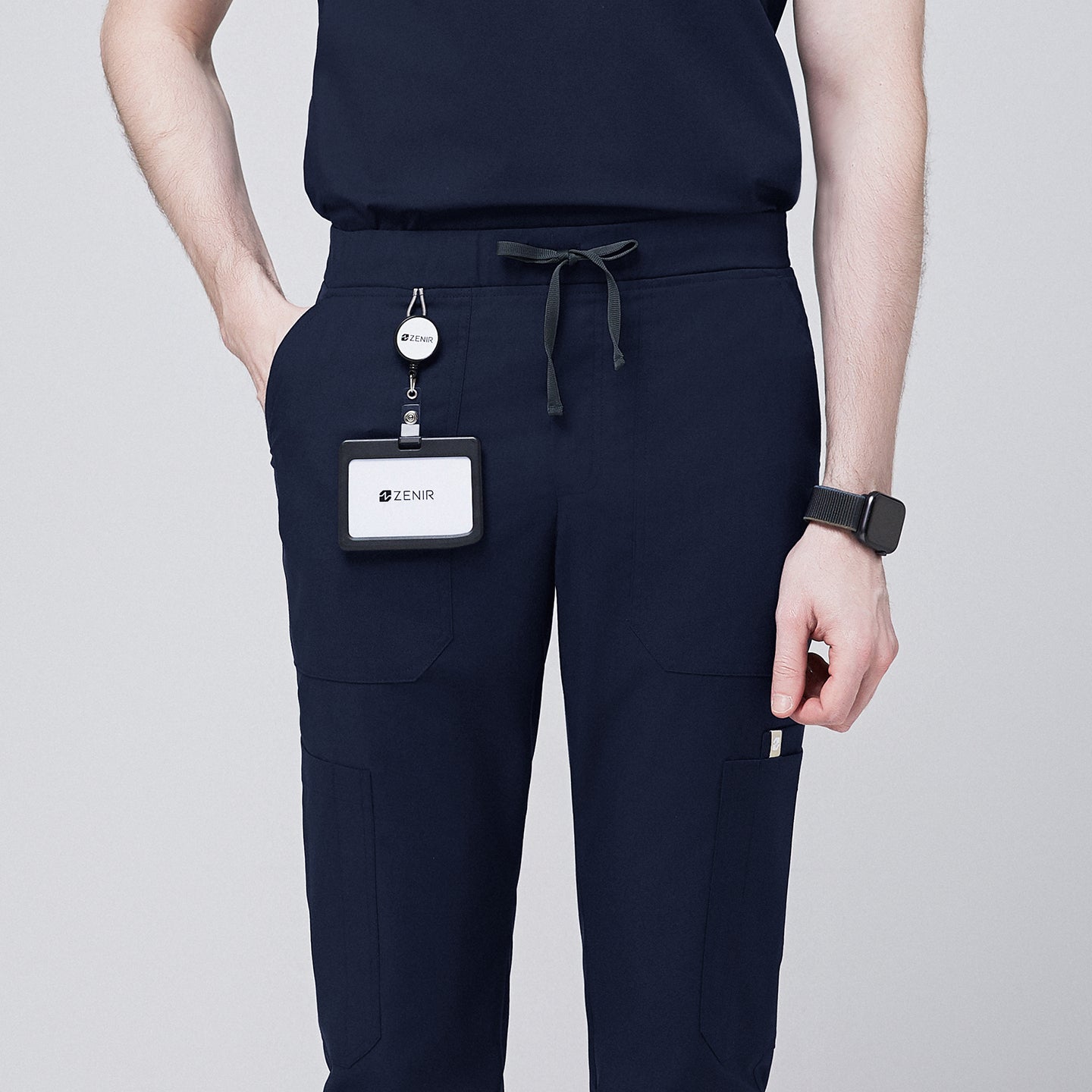 Close-up of navy jogger scrub pants with drawstring waistband, 8 pockets, and a Zenir name badge for added functionality,Eco Navy