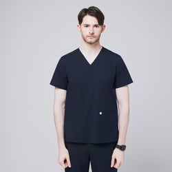 Image of Male model wearing a navy V-neck scrub top with double front pockets, presenting a clean and professional front view, ideal for medical or healthcare settings,Eco Navy