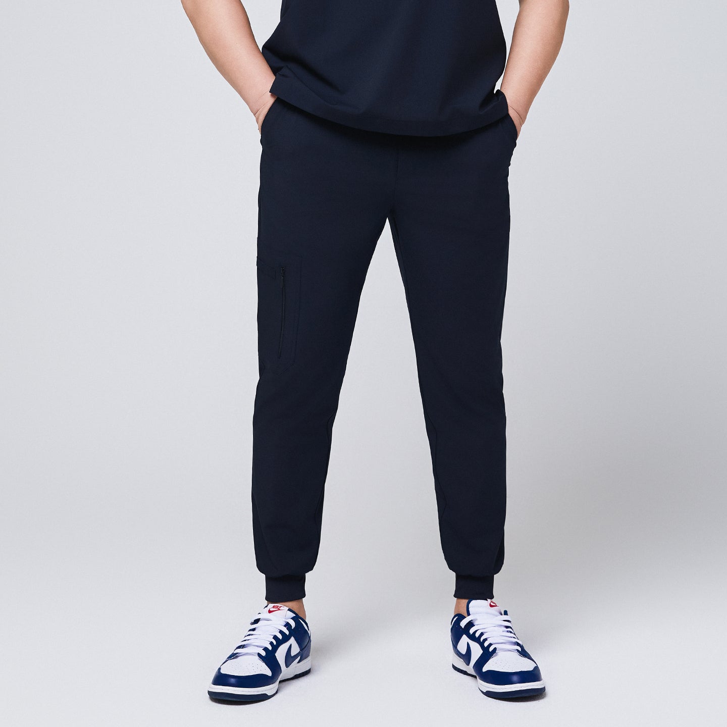 Front view of navy jogger scrub pants with a zipper pocket and elastic cuffs,Eco Navy