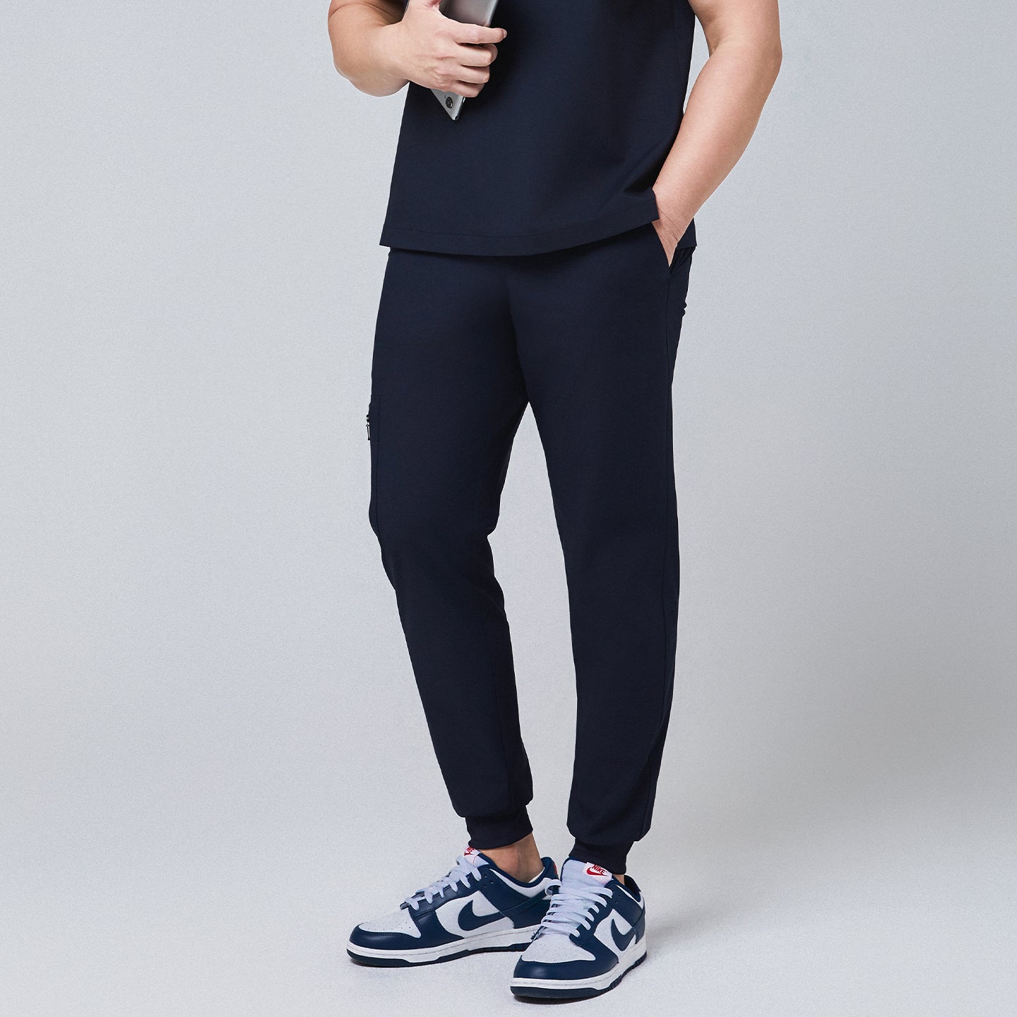 Side view of navy jogger scrub pants featuring a zipper pocket and elastic cuffs,Eco Navy