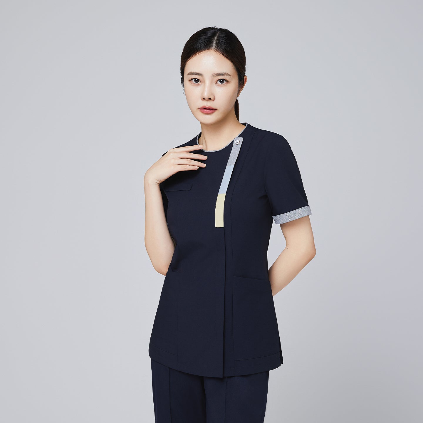 Navy scrub top with triple-tone accents and front zipper, modeled by a woman, suitable for professional settings,Eco Navy