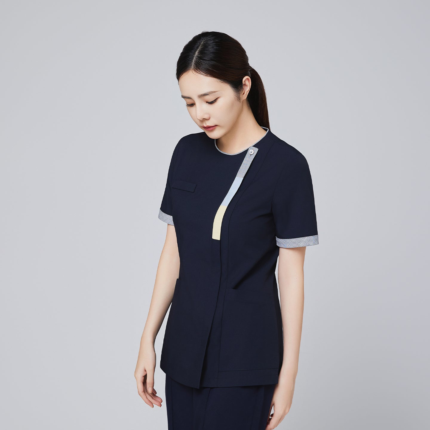 Side view of navy scrub top with triple-tone front zipper and cuff detailing, designed for professional use,Eco Navy