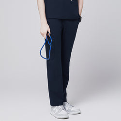 Image of A model wearing navy straight scrub pants with a zipper pocket and matching scrub top, holding a blue stethoscope, paired with white sneakers,Eco Navy