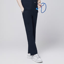 Image of A model showcasing navy straight scrub pants with a zipper pocket and matching top, holding a blue stethoscope and styled with white sneakers,Eco Navy