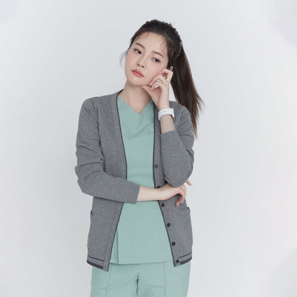 Woman wearing a gray soft touch cardigan over a green top and pants, with a smartwatch on her wrist, posing thoughtfully,Gray