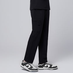 Image of Male model showcasing jet black relaxed-fit scrub pants with functional side pocket design, paired with black and white sneakers, highlighting a professional yet comfortable style,Jet Black