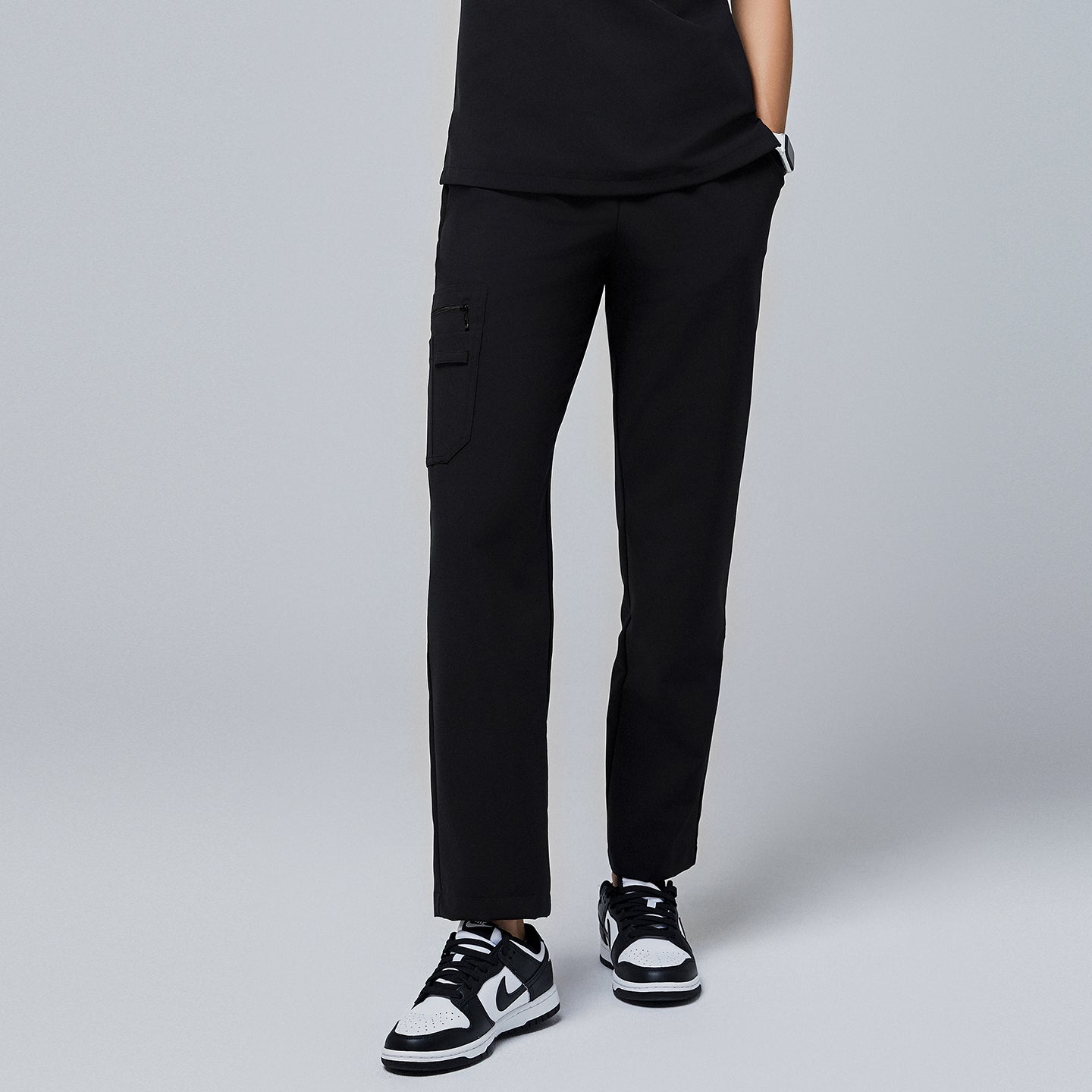 Black utility scrub pants with a side pocket, paired with black-and-white sneakers,Jet Black