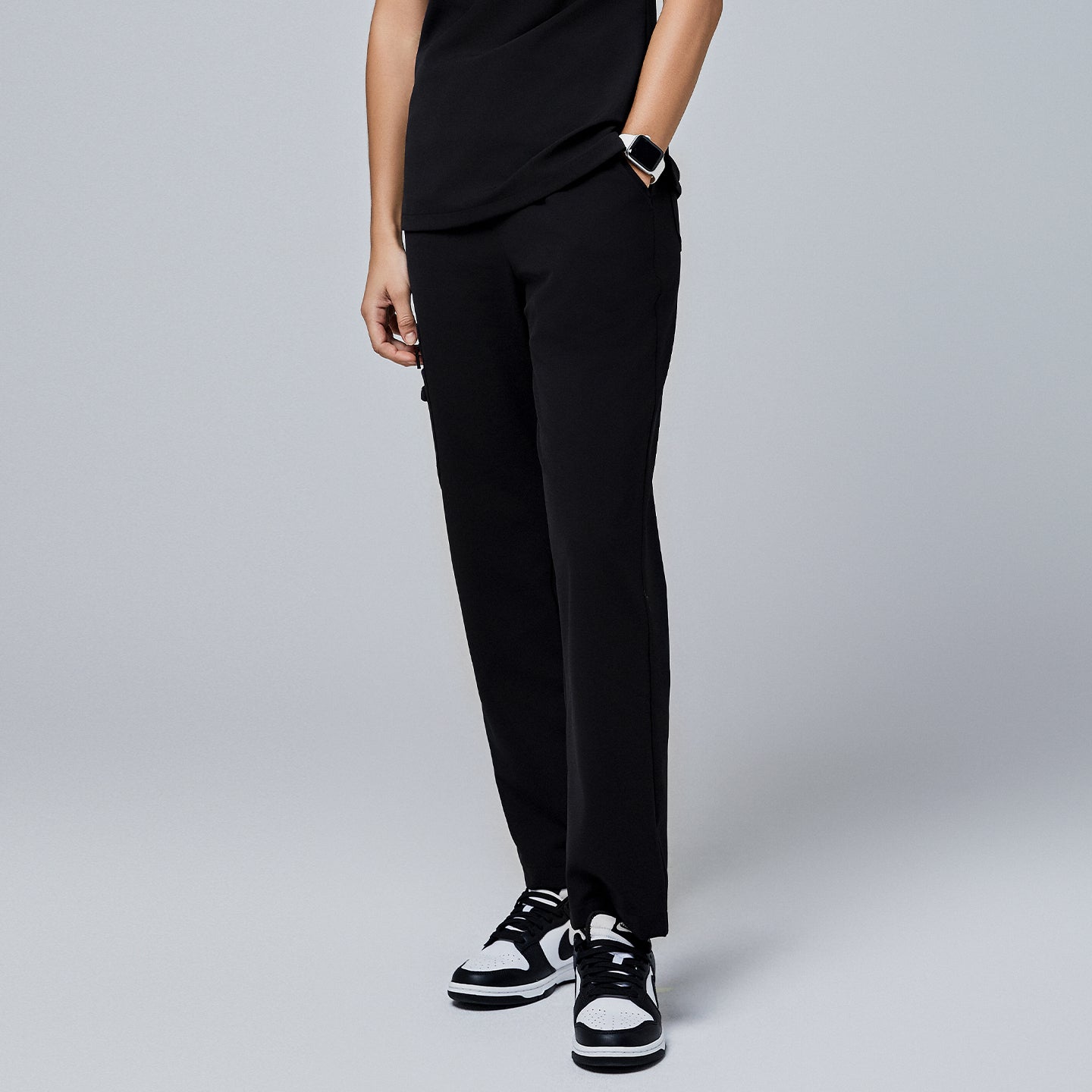 Black utility scrub pants featuring a streamlined fit and side pockets, styled with black-and-white sneakers and a smartwatch,Jet Black