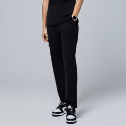 Image of Black utility scrub pants featuring a streamlined fit and side pockets, styled with black-and-white sneakers and a smartwatch,Jet Black