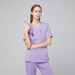 Image of Lavender pleated shoulder scrub top and pants with v-neck, holding pink stethoscope,Lavender