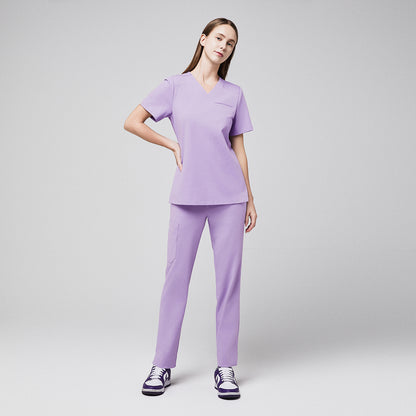 Female healthcare professional in lavender scrubs with side pocket pants and purple sneakers, standing confidently,Lavender