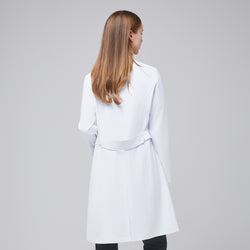 Image of Back view of a woman wearing a long white lab coat (LCW-04), highlighting the buttoned belt detail, over Deep Gray scrubs,White