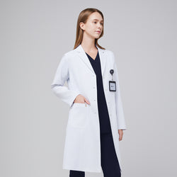 Image of A woman wearing a long white lab coat (LCW-04) over an Eco Navy Single Pocket Scrub Top and Eco Navy Zipper Pocket Jogger Scrub Pants, with an ID badge attached to the coat,White