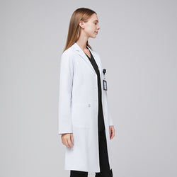 Image of Side view of a woman wearing a long white lab coat (LCW-04) over a Midnight Black Single Pocket Scrub Top and Midnight Black Zipper Pocket Jogger Scrub Pants,White