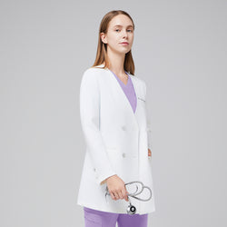 Image of A woman wearing a white long lab coat (LCW-09) over a Lavender Pleated Shoulder Scrub Top and Lavender Straight Split Hem Scrub Pants, holding a stethoscope,White