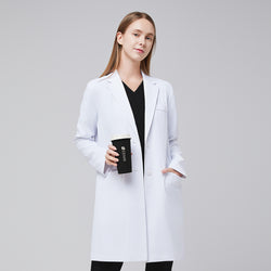 Image of A woman wearing a white long lab coat (LCW-10) over a black scrub top and pants, holding a coffee cup,White






