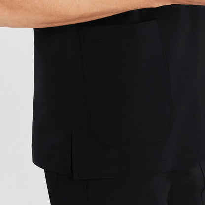 Close-up of a man wearing a scrub top, showing the side pocket and the side slit detail for added comfort and functionality,Black