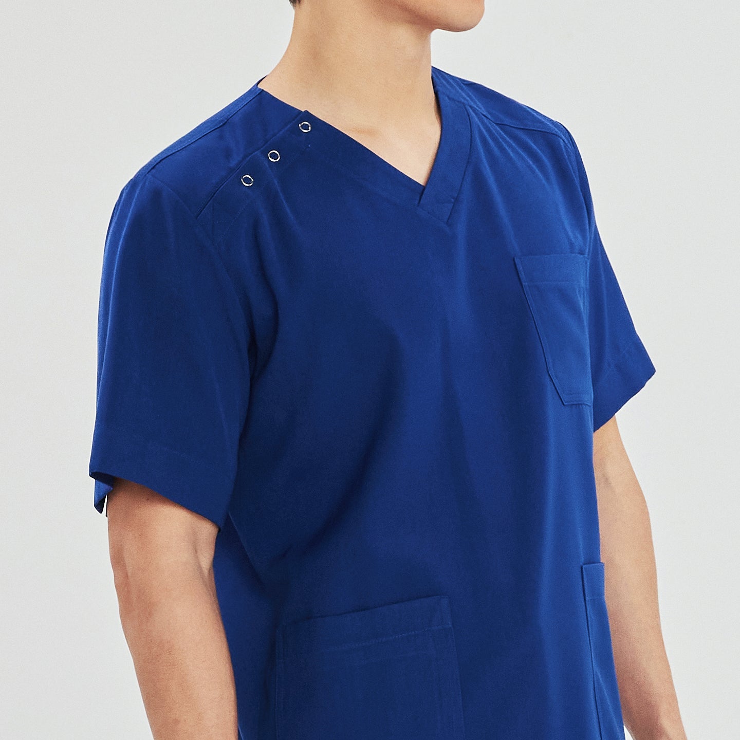 Close-up of a man wearing a scrub top with a V-neck, three-button shoulder detail, and a front chest pocket,Royal Blue