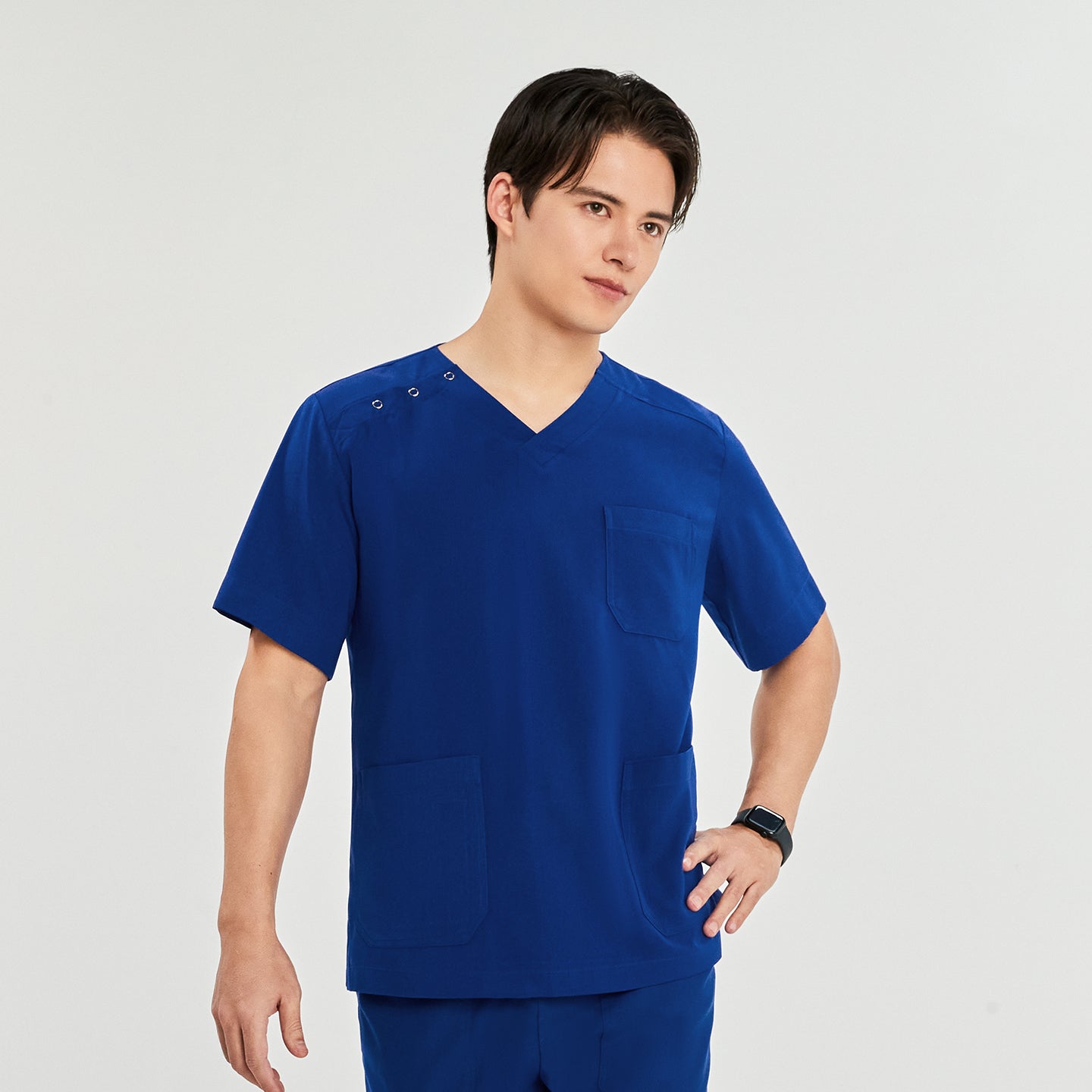  A man standing confidently, wearing a scrub top with a V-neck, three-button detail on the shoulder, and multiple pockets,Royal Blue