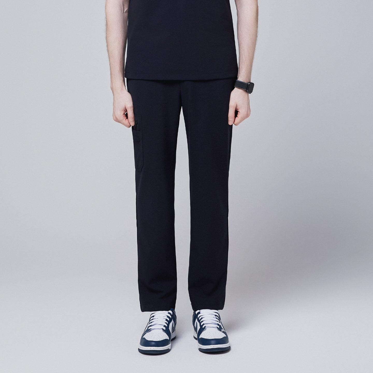 Male model wearing midnight navy relaxed-fit scrub pants with side pocket, standing in a neutral pose, showing the front view of the pants, against a plain background,Midnigh Navy