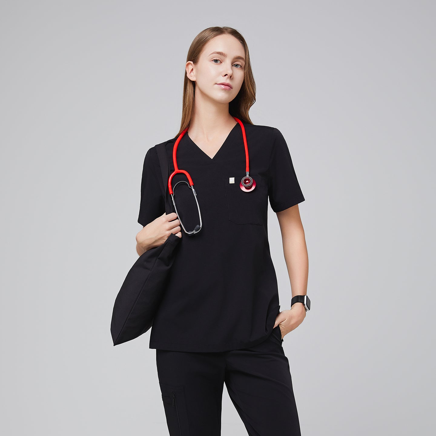 Female healthcare professional wearing a midnight black scrub set with a red stethoscope, holding a black bag in a confident pose,Midnight Black