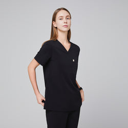 Image of Female healthcare professional in a midnight black scrub set, standing in a side pose with a relaxed posture,Midnight Black