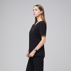 Image of Side view of a female healthcare professional wearing a midnight black scrub set with a smart watch, standing confidently,Midnight Black