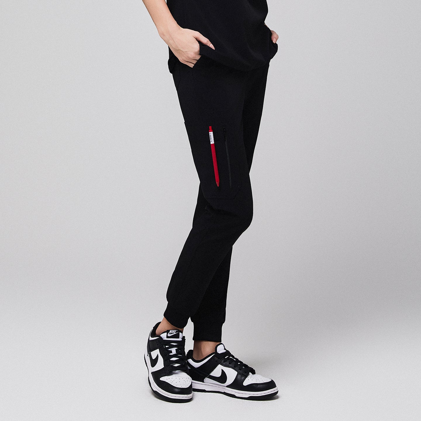 Jogger-style scrub pants with a zippered side pocket and sneakers worn by a medical professional,Midnight Black