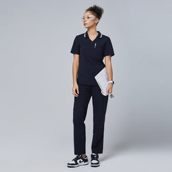 Image of Woman in a navy blue polo scrub top with white striped collar and matching pants, holding a clipboard and stethoscope,Midnight Navy