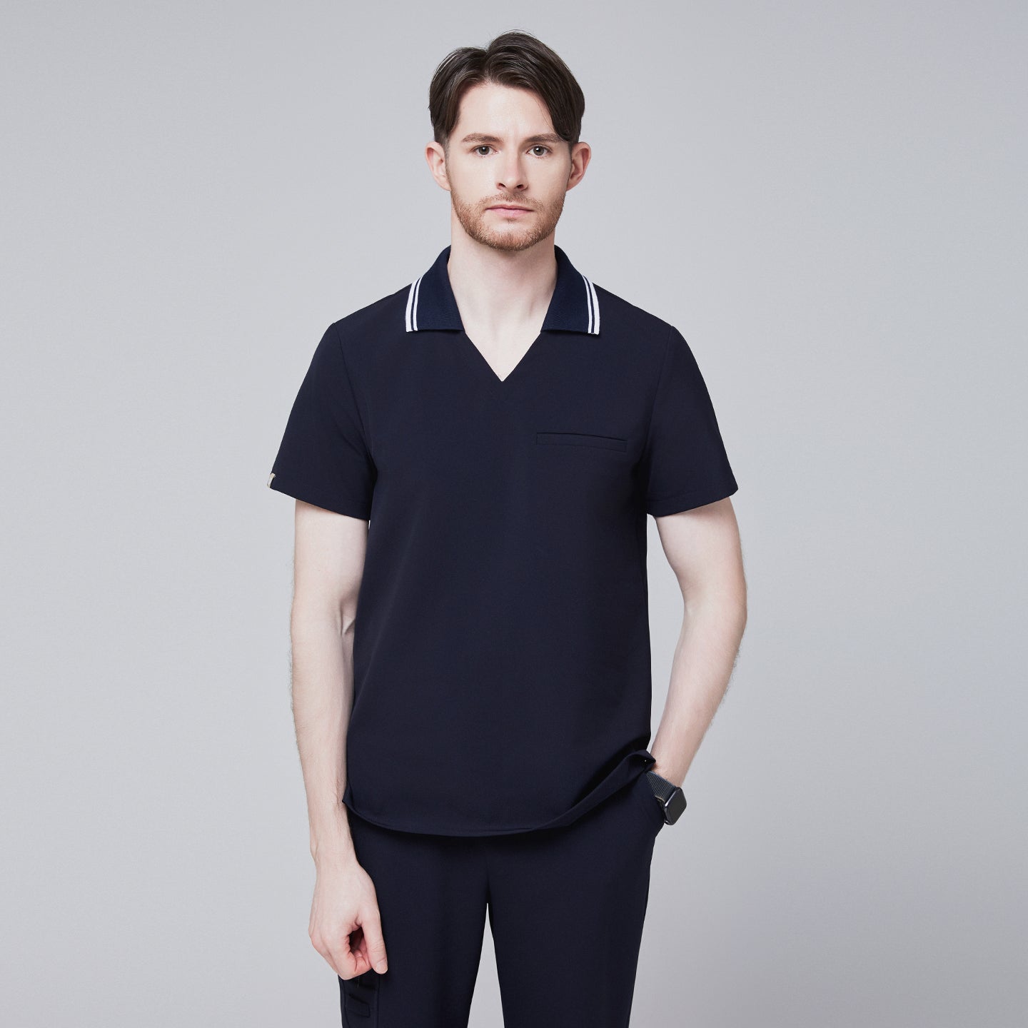 Male model wearing a midnight navy performance polo scrub top with a striped collar,Midnight Navy