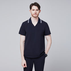 Image of Male model wearing a midnight navy performance polo scrub top with a striped collar,Midnight Navy