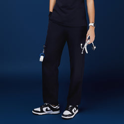 Image of Navy utility scrub pants with functional side pockets, styled with a navy top, stethoscope, and black-and-white sneakers,Midnight Navy