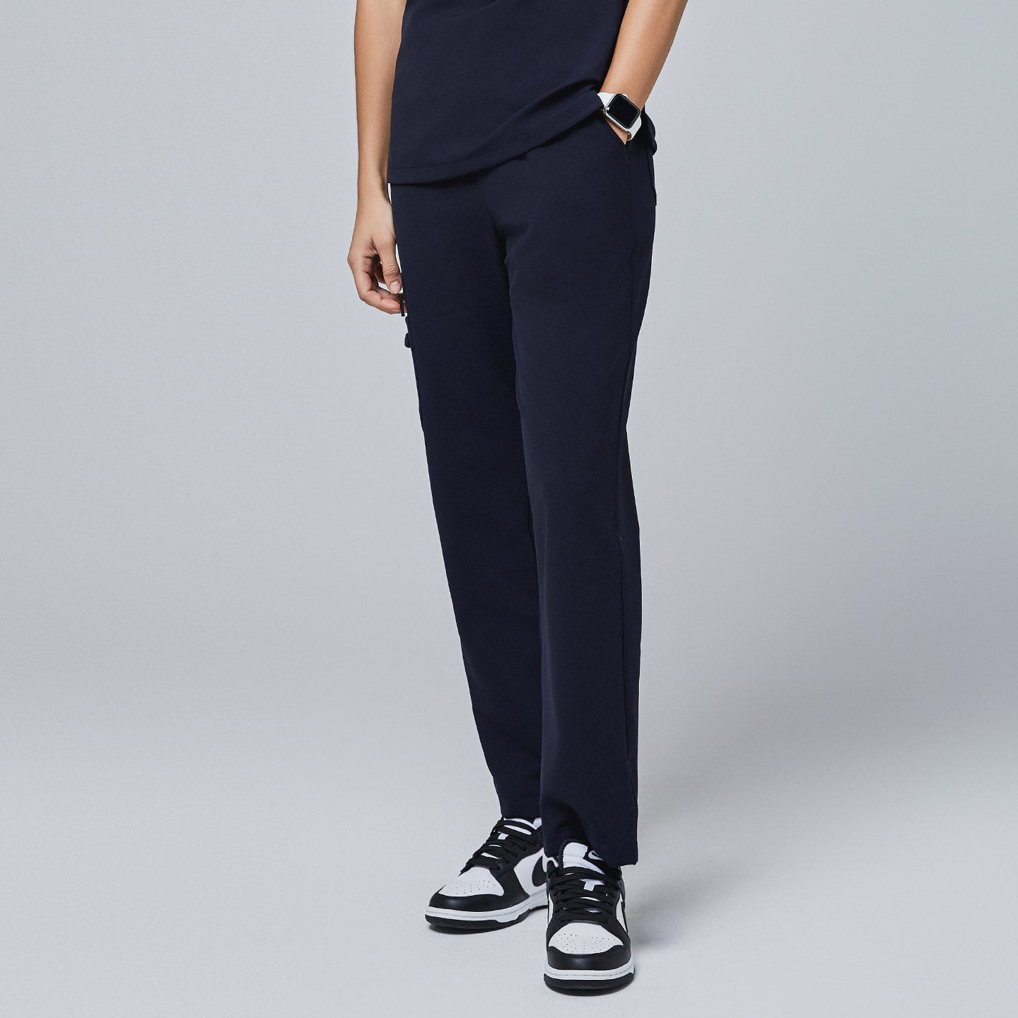 Navy utility scrub pants with a clean design and side pockets, paired with black-and-white sneakers and a smartwatch,Midnight Navy