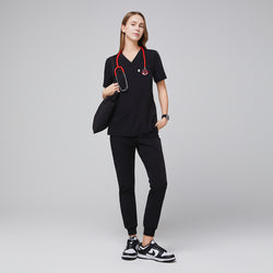 Image of Medical professional wearing jogger-style scrub pants with a stethoscope and carrying a bag,Midnight Black