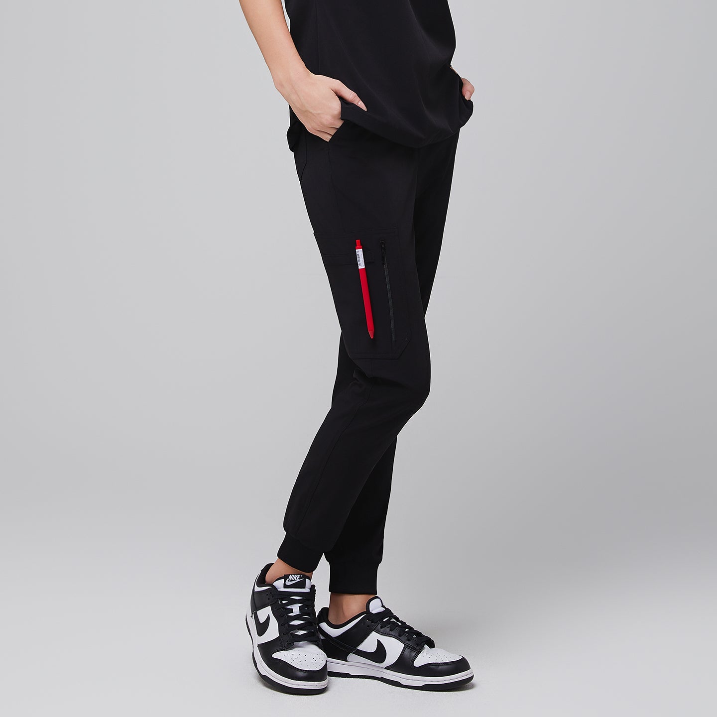 Jogger-style scrub pants with a zippered side pocket and sneakers worn by a medical professional,Midnight Black