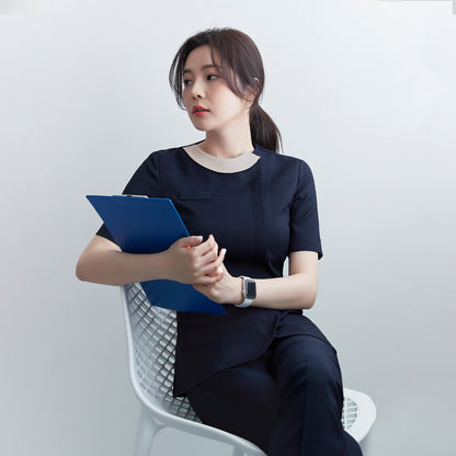  A woman in a navy round-neck front zipper top and matching pants, sitting on a white chair, holding a blue clipboard. She wears a smartwatch,Mir Navy