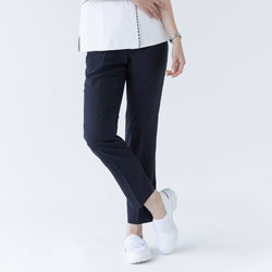 Image of Woman in navy side-banding scrub pants, white top with detailing, and white shoes,Mir Navy