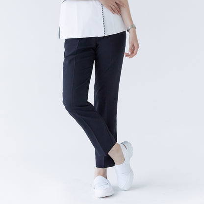 Woman in navy side-banding scrub pants, white top with detailing, and white shoes,Mir Navy